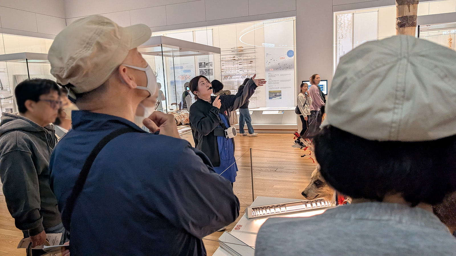 参加者に博物館の展示を説明する女性
