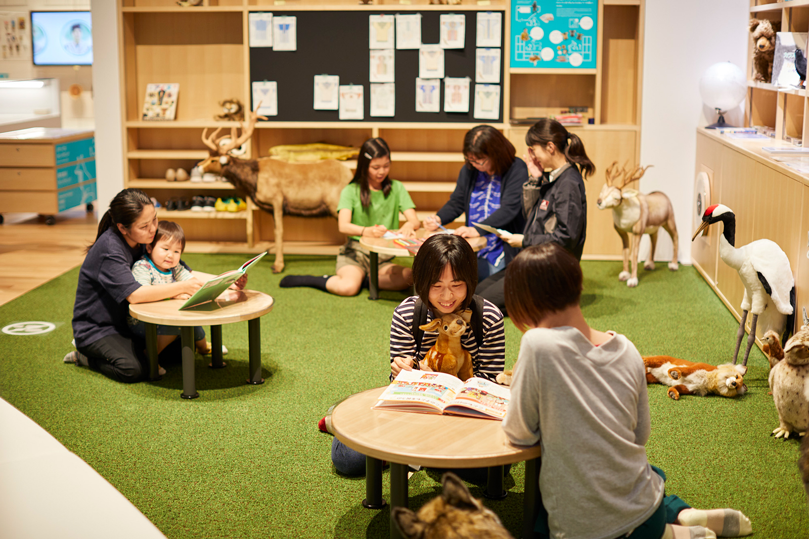 テーブルで絵本を読む女性と子ども