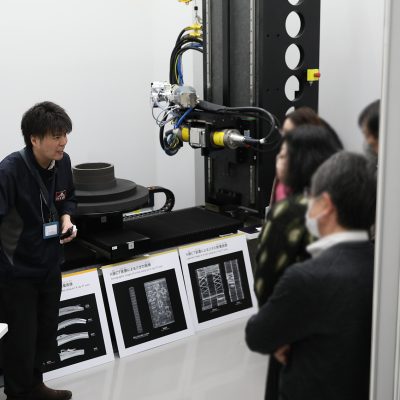 分析機の前で来館者に説明をする男性