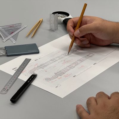 鉛筆で図面に書き込む手元