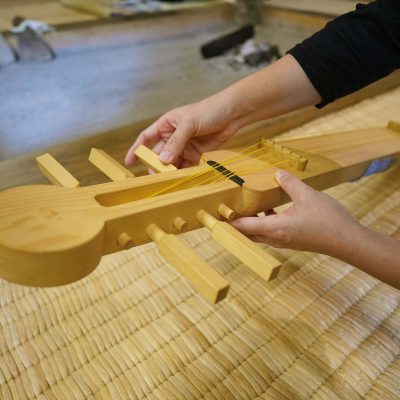 木製の弦楽器を触る手元