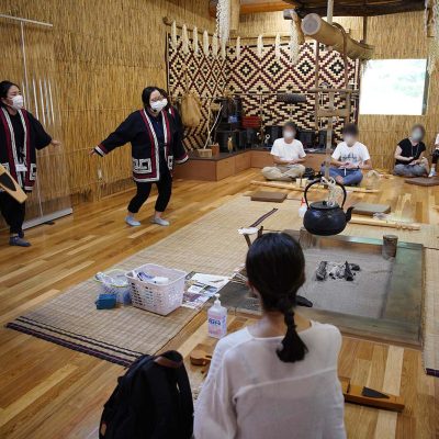 囲炉裏の前で歌い踊る着物を来た女性