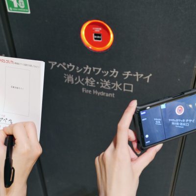 消火栓を撮影する手元とメモに記載する手元