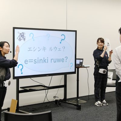 エシンキ　ルウェ？と表示されたモニターを前に男性に説明をする2人の女性